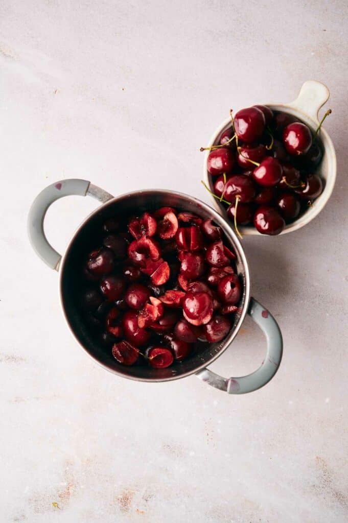 Cherries in a bowl on a white surface.