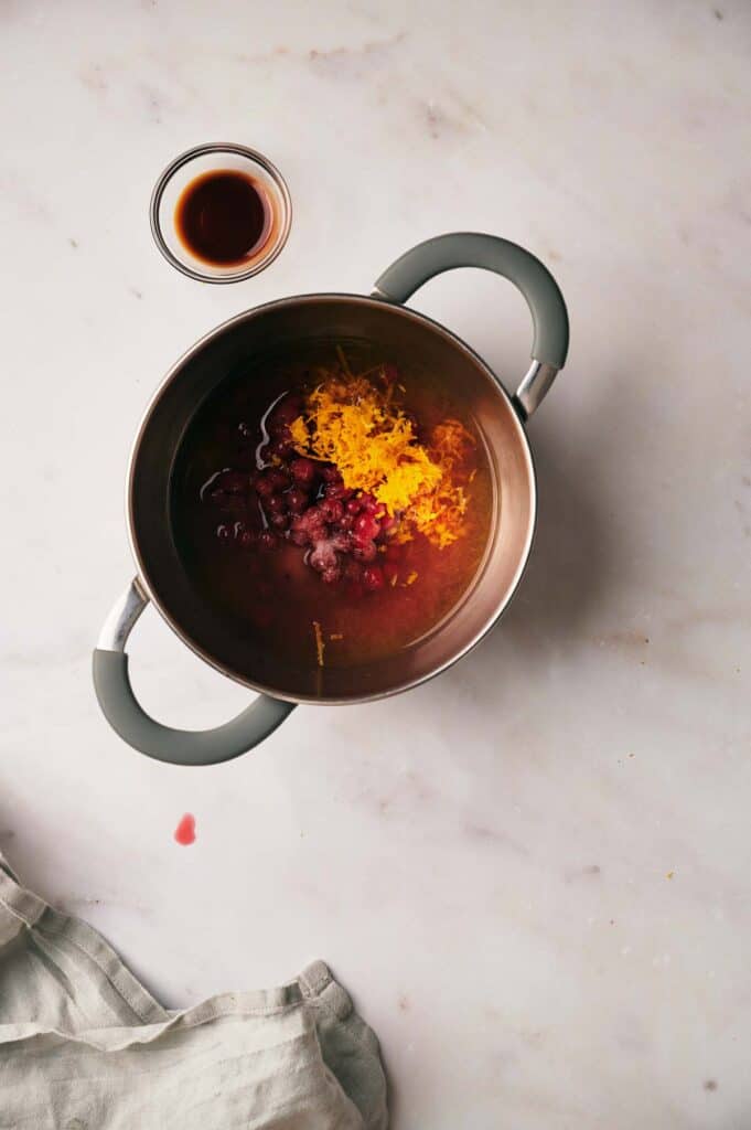 A pot with a cup of liquid next to it.