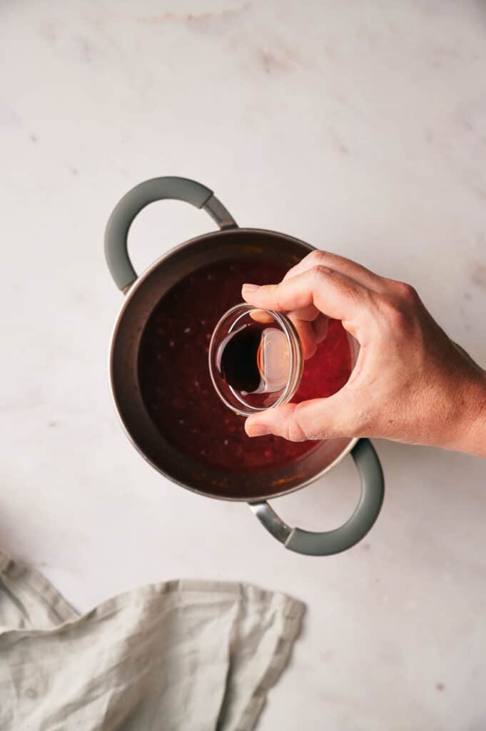 A person pouring liquid into a pot.