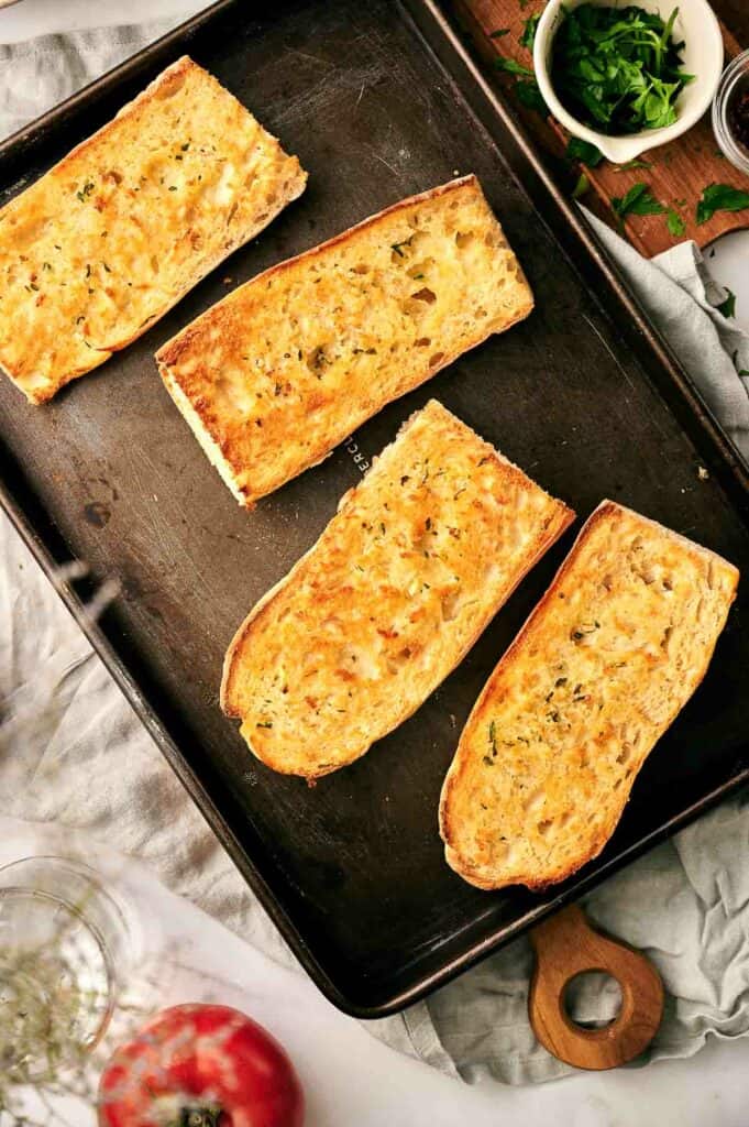 Four slices of bread on a baking sheet.