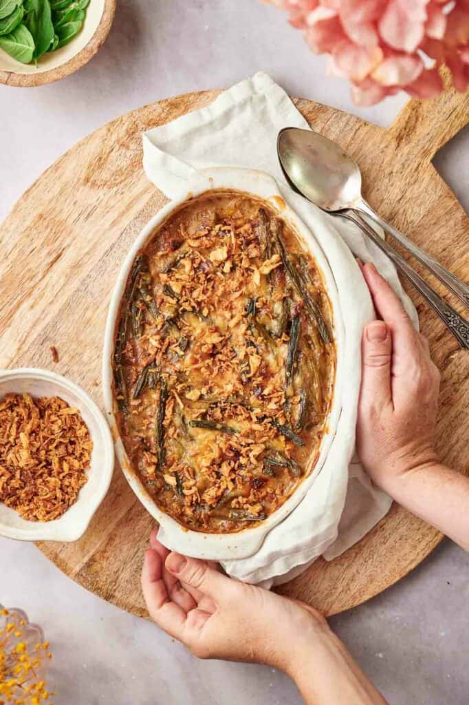 A person holding a dish of green bean casserole.
