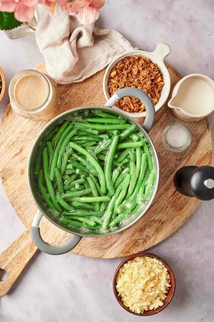 Green beans in a pan on a wooden board.