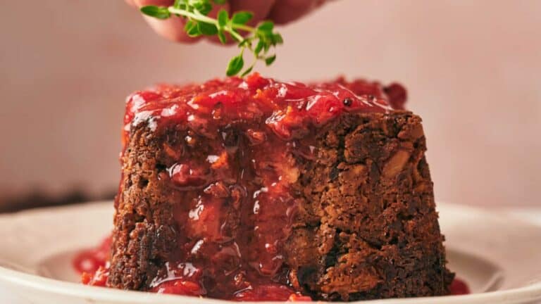 Christmas pudding with cranberry sauce on a plate.