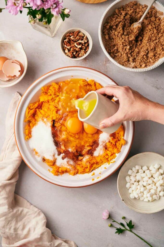 A person is preparing sweet potatoes in a bowl.