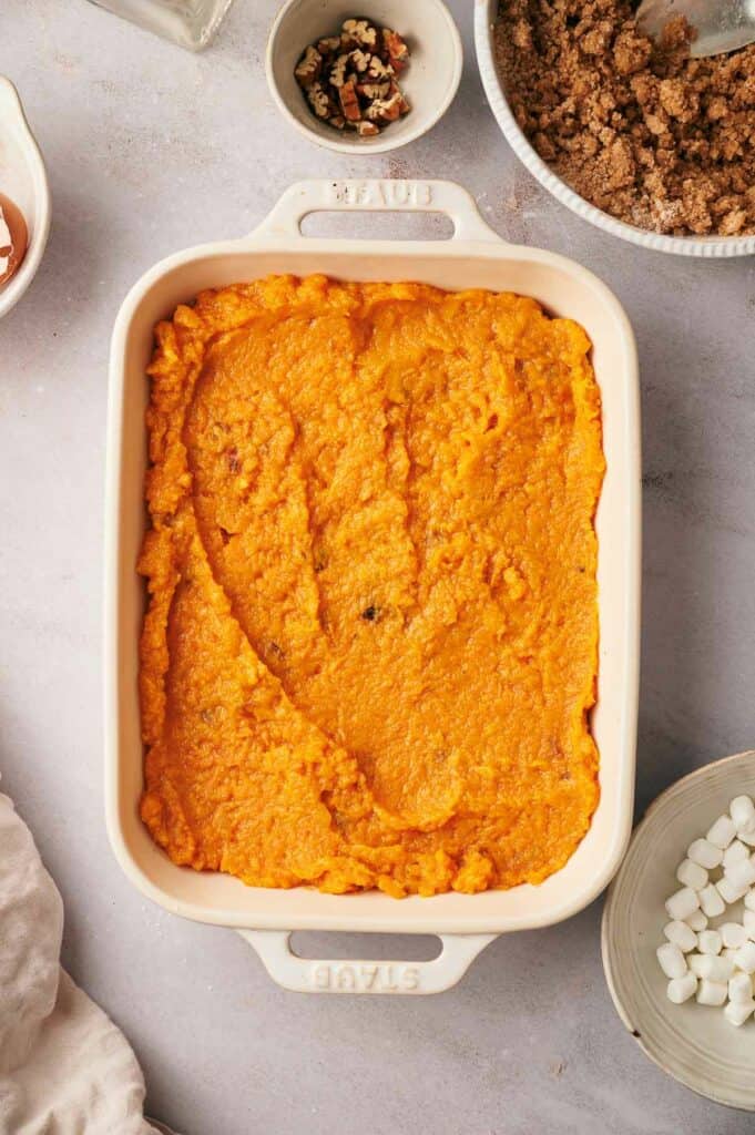 A dish of sweet potato casserole with marshmallows and other ingredients.