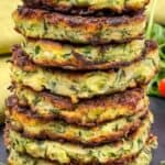 Zucchini fritters are stacked on top of each other.