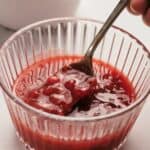 A bowl of cranberry sauce with nuts in it.