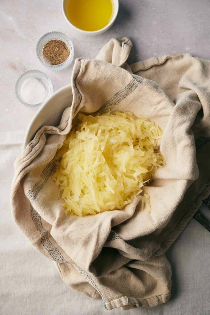 Shredded potatoes in a cloth on a table.