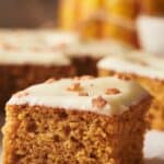 Pumpkin bars with icing on a white plate.