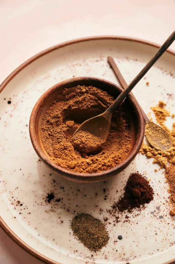 Spices in a bowl on a plate.