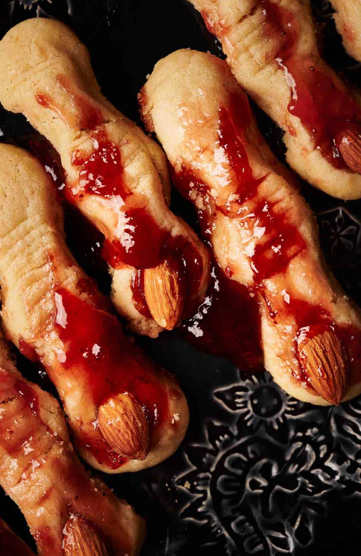 A plate of cookies with jam and almonds on it.