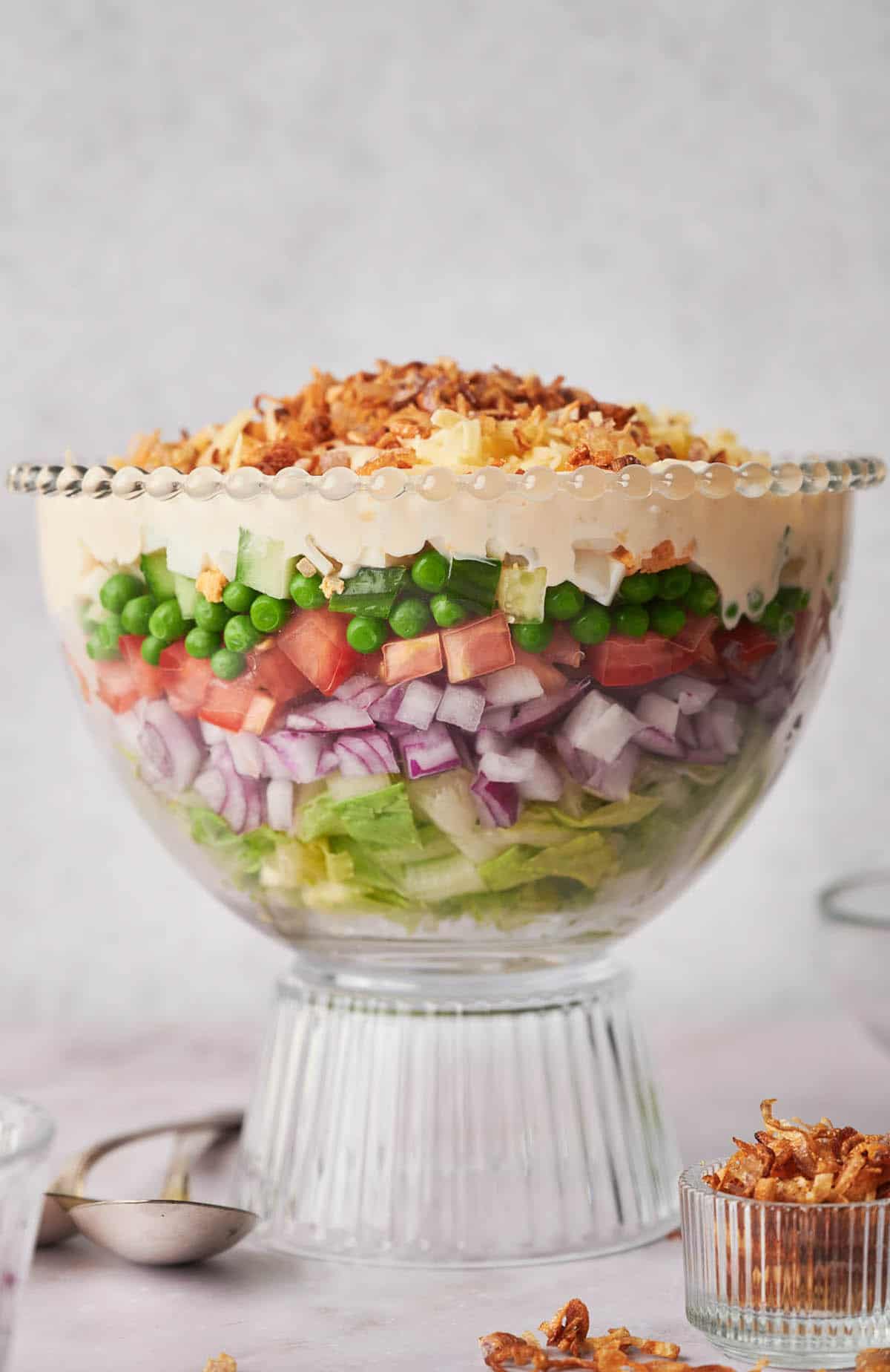 A glass bowl with a 7 layer salad in it.