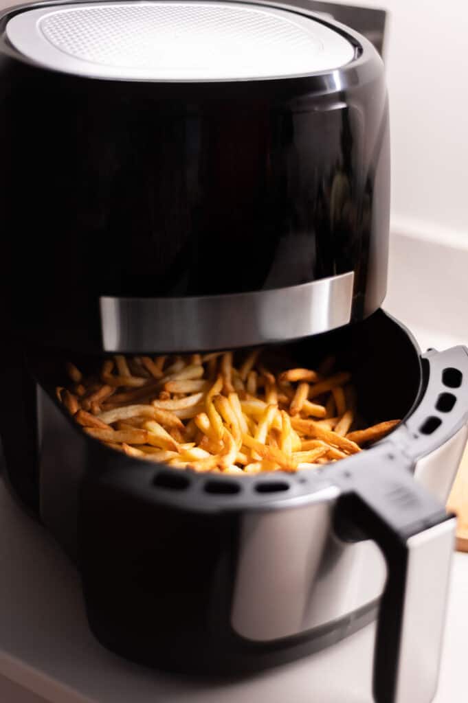 An air fryer filled with french fries.