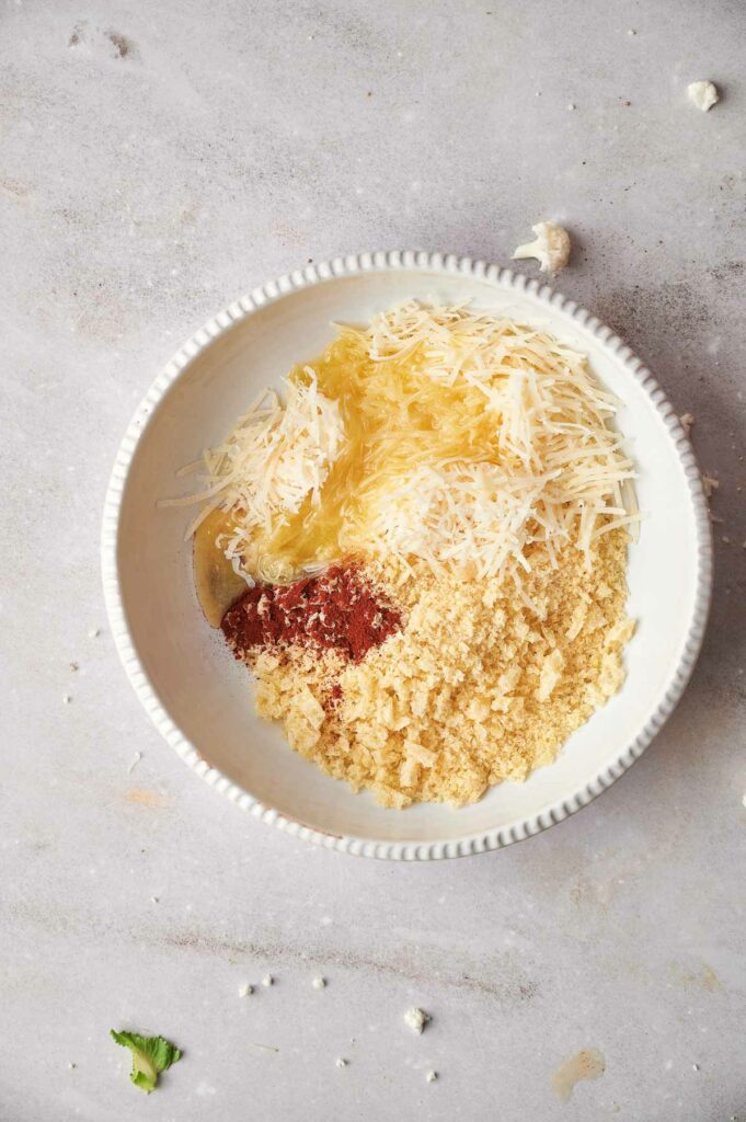 A bowl of ingredients with sauce and cheese in it.