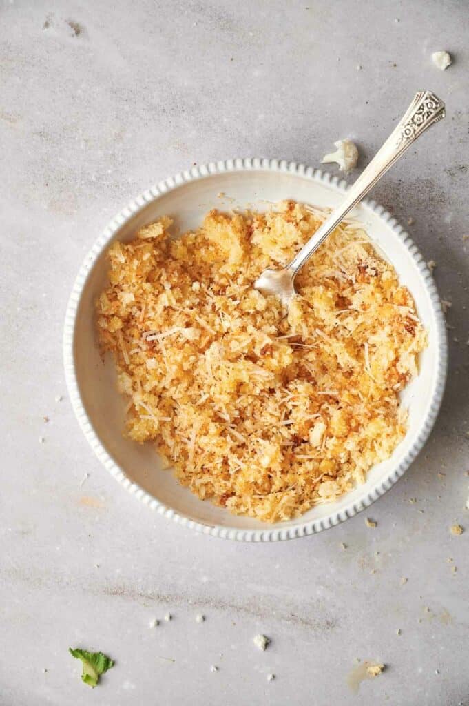 A bowl of shredded cheese with a spoon.