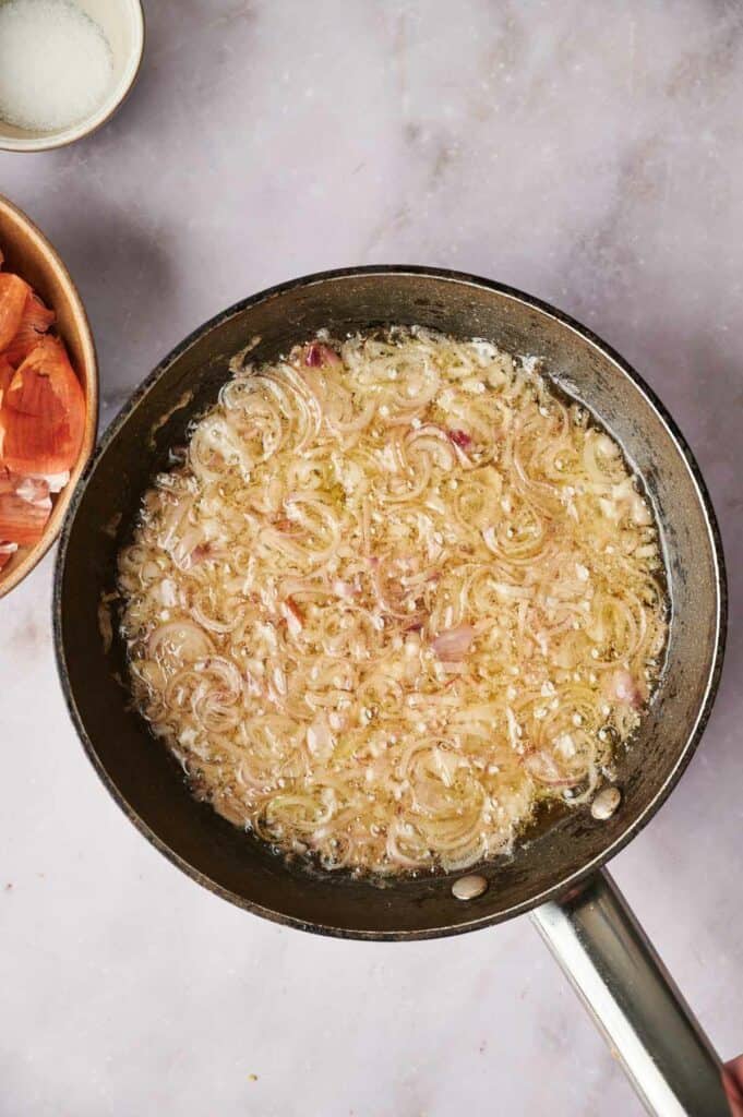 A frying pan with crispy shallots in it.