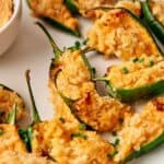 Jalapeno poppers on a plate with dipping sauce.