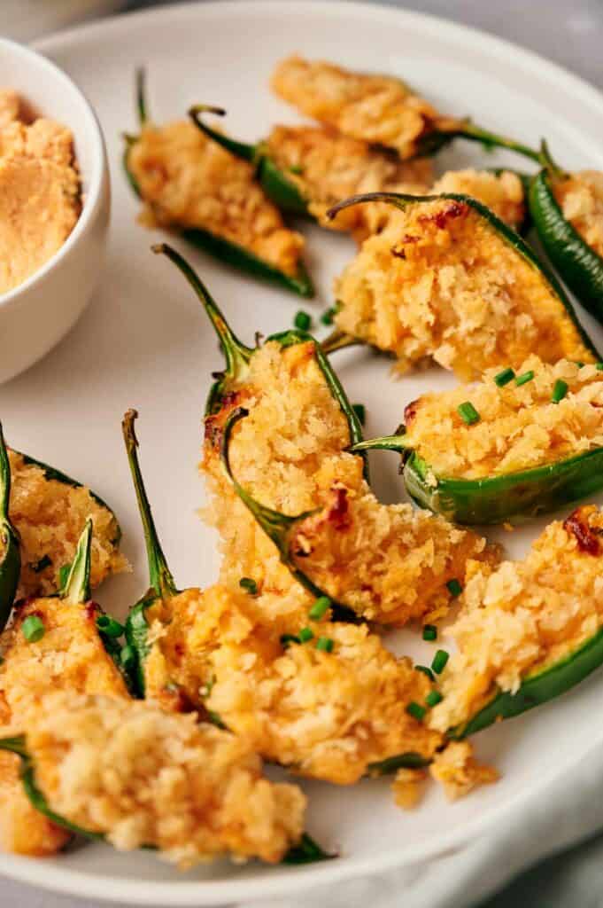 Jalapeno poppers on a white plate with dip.