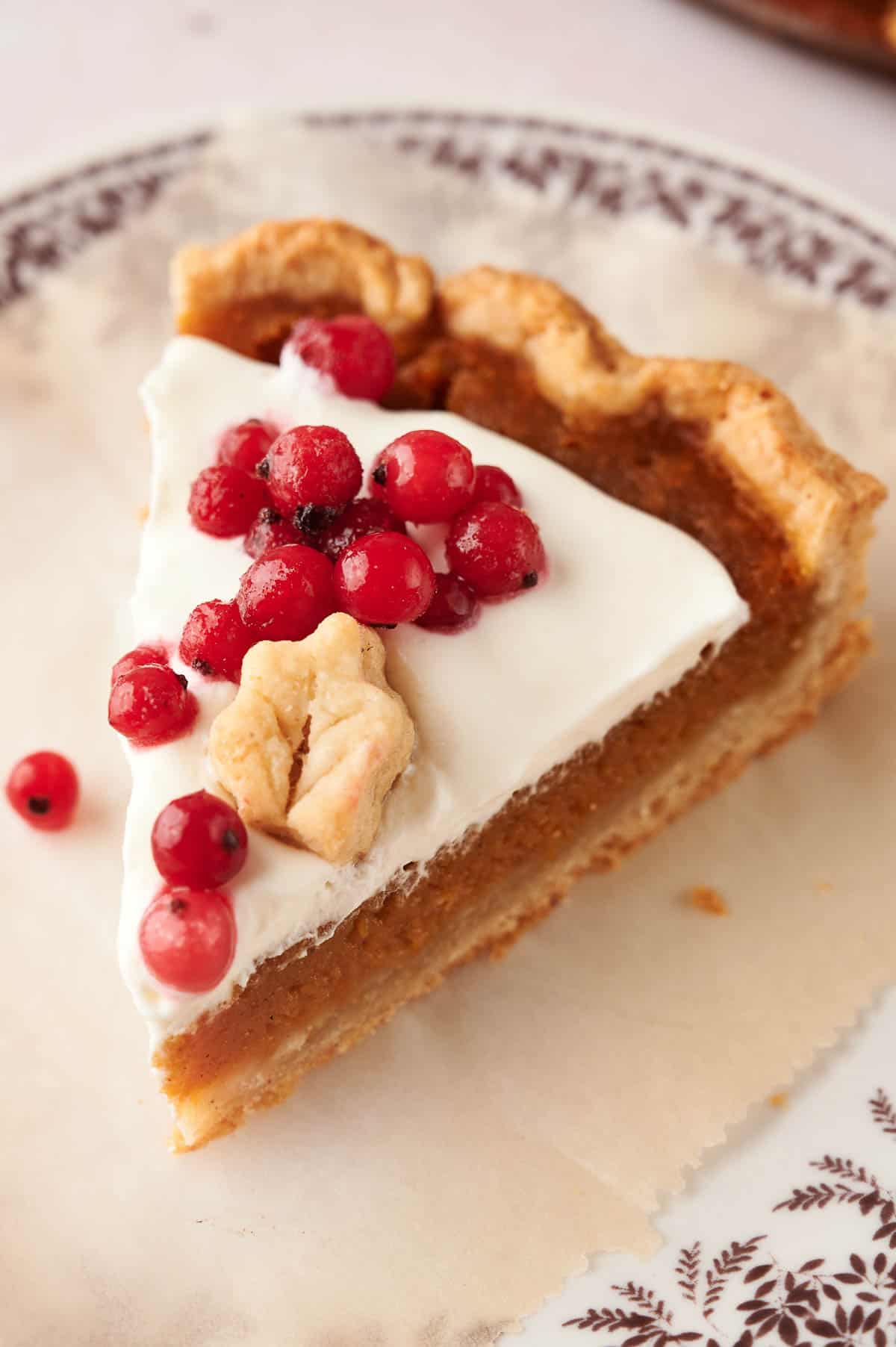 A slice of delicious pumpkin pie with cranberries on a plate.