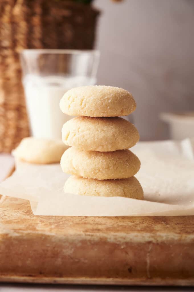 A stack of cookies next to a glass of milk.