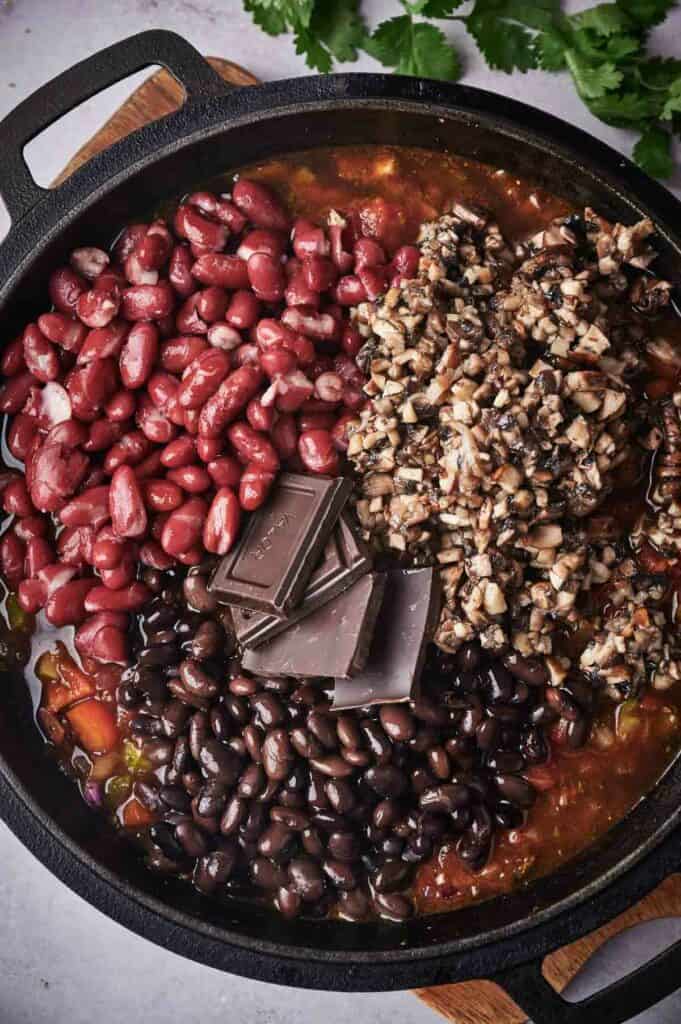 A skillet filled with beans, nuts and chocolate.