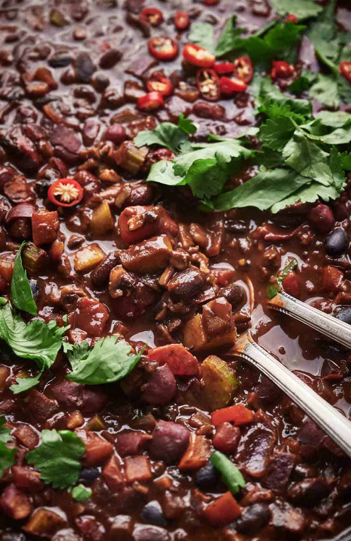 A bowl of chili with two forks in it.