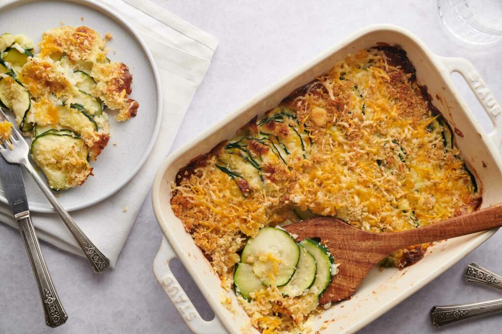 Cheesy zucchini casserole on a plate with a fork.