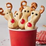 Reindeer cookie pops in a red cup.