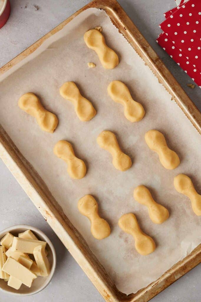 A baking sheet with reindeer cookies on it.