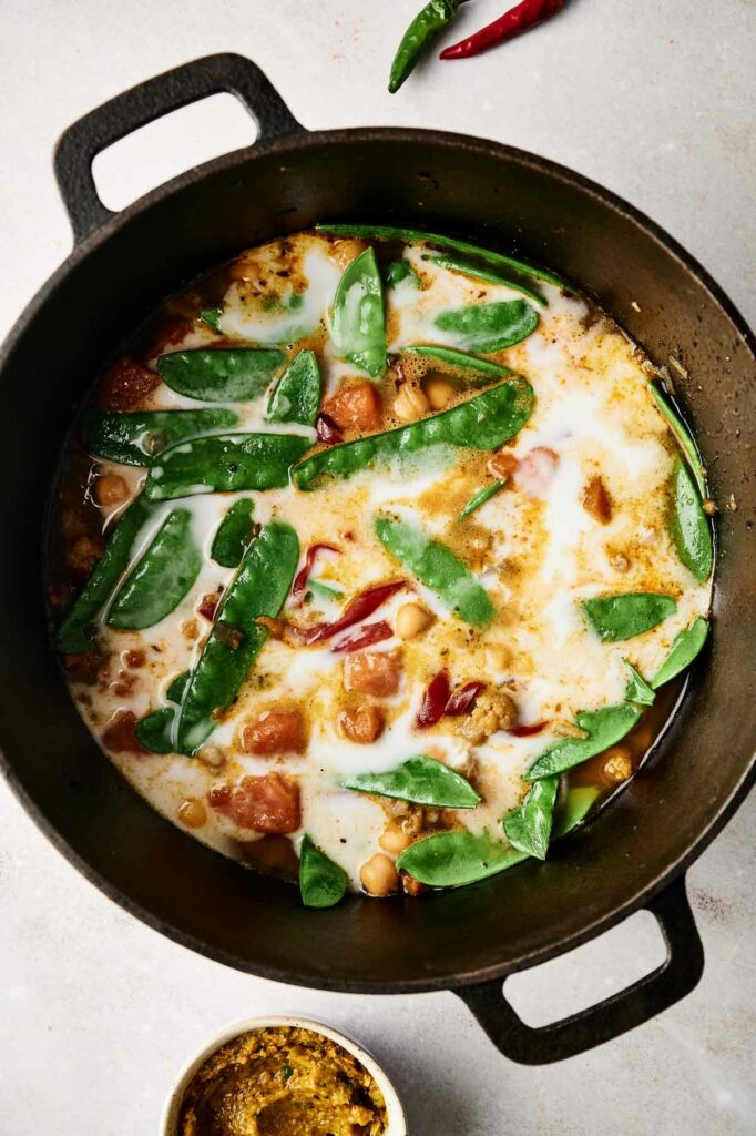A pot filled with vegetables and coconut milk.