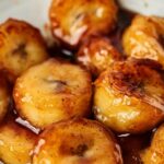 Fried bananas in a white bowl with the text fried bananas.