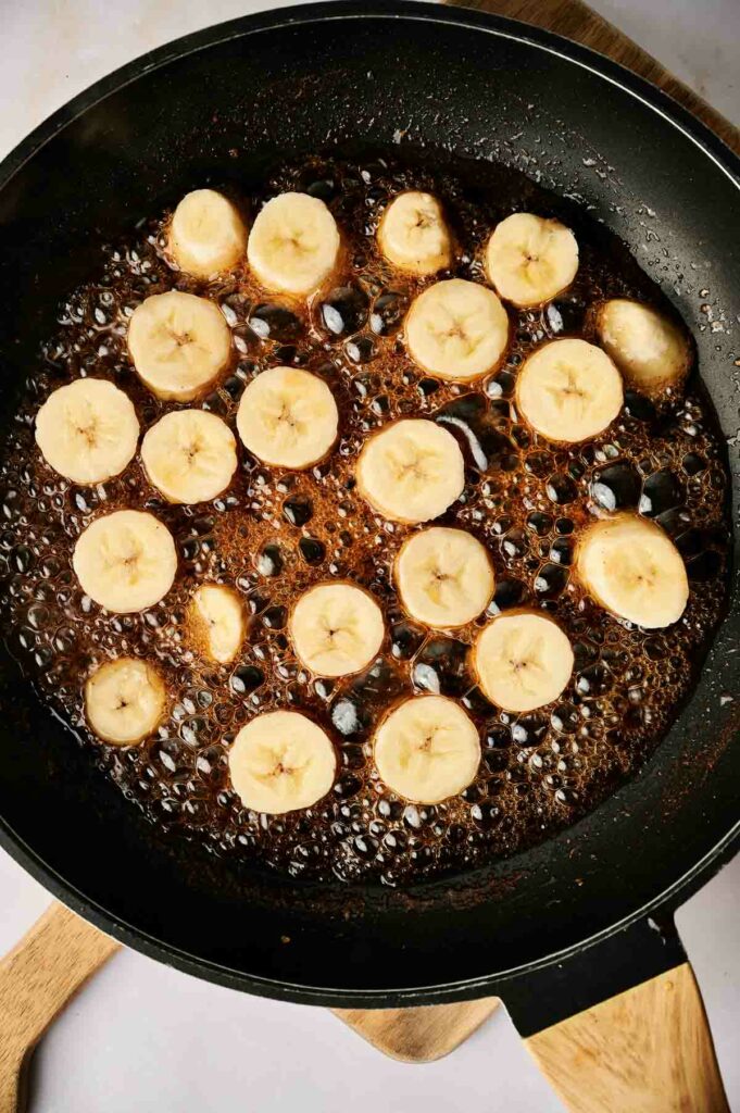 A frying pan with banana slices in it.