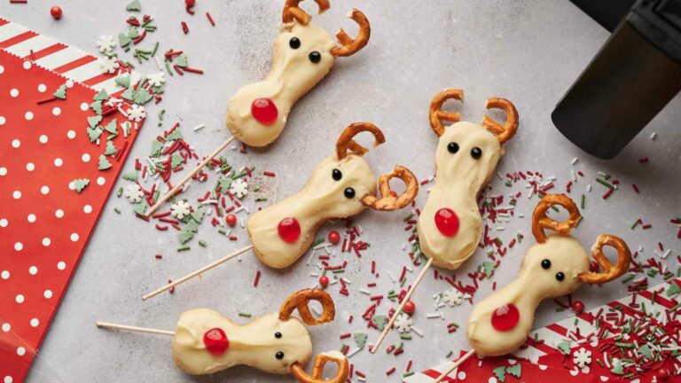 Snowman cookies on a stick with sprinkles.