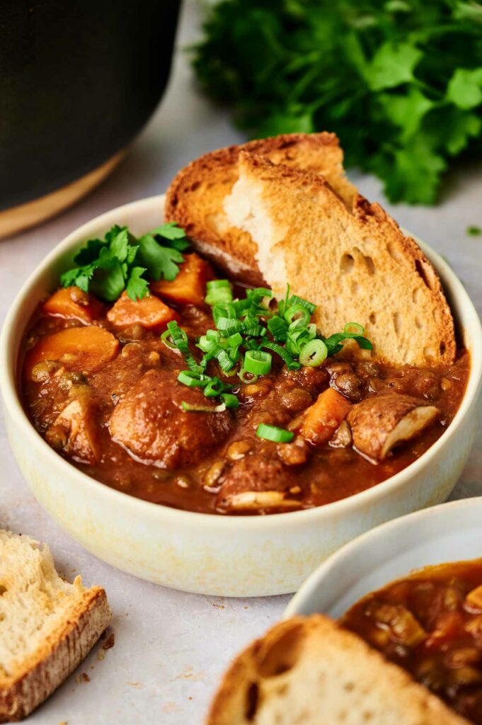 A delicious bowl of stew with a side of fresh bread.