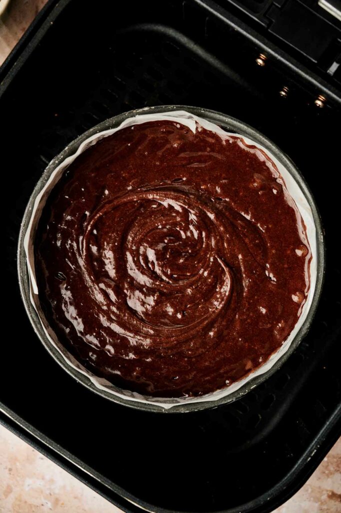 A pan of chocolate cake batter in an air fryer.