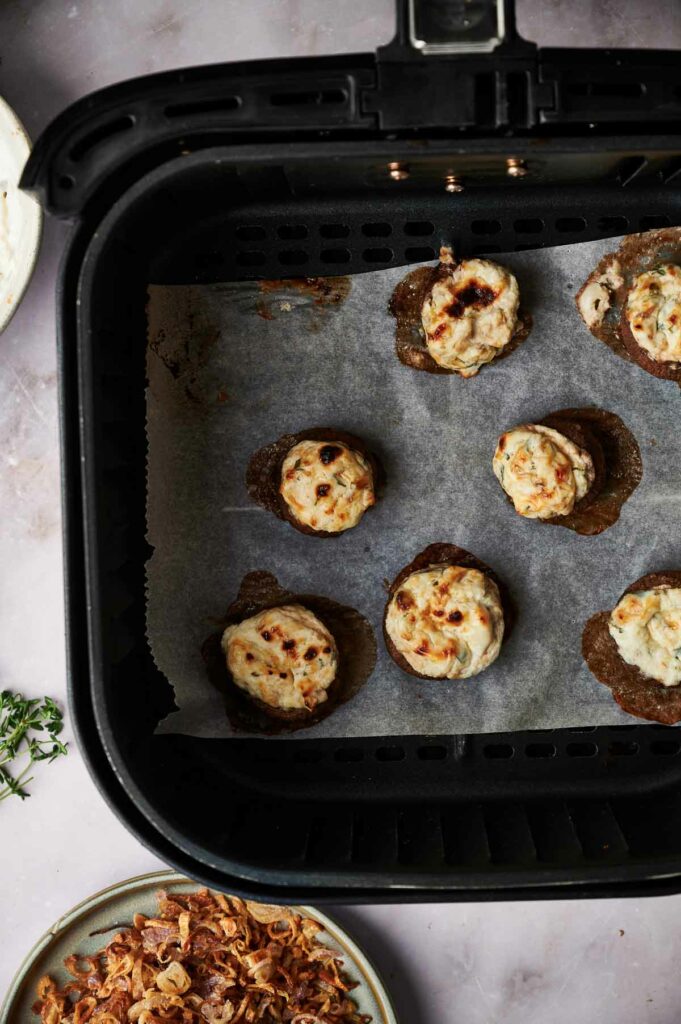 The air fryer is filled with stuffed mushrooms.