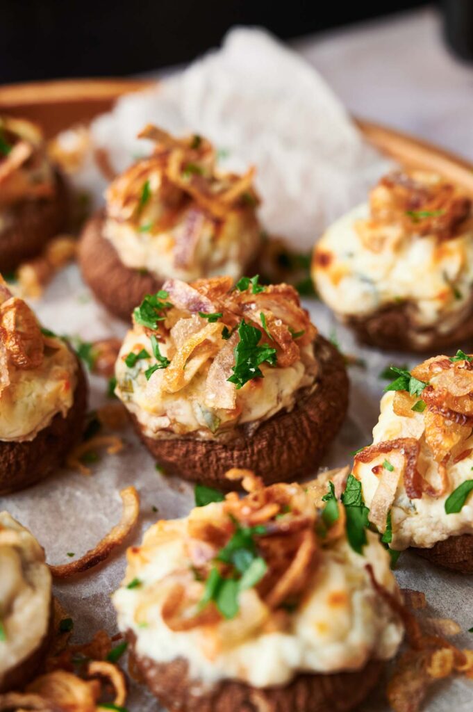 Air fryer stuffed mushrooms with cheese and onions on a plate.