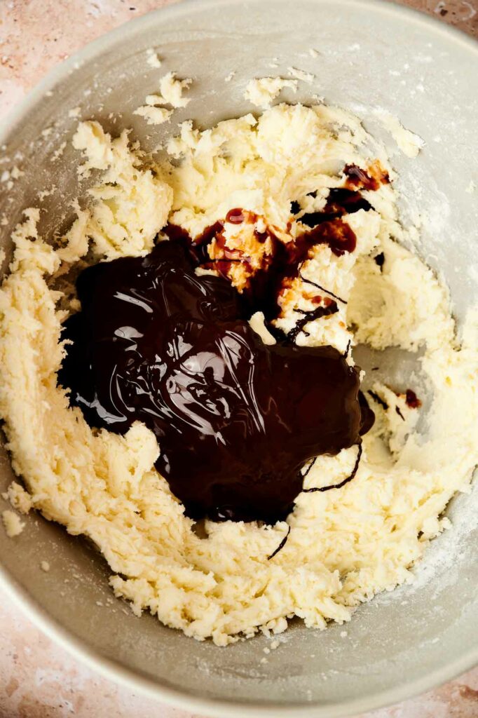 A bowl of dough with a drizzle of chocolate sauce on it.