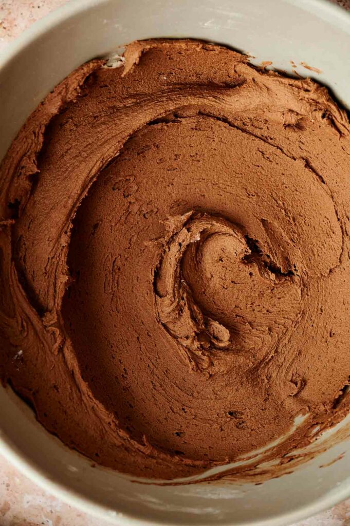A bowl of chocolate icing with a swirl in it, perfect for decorating your air fryer cake.