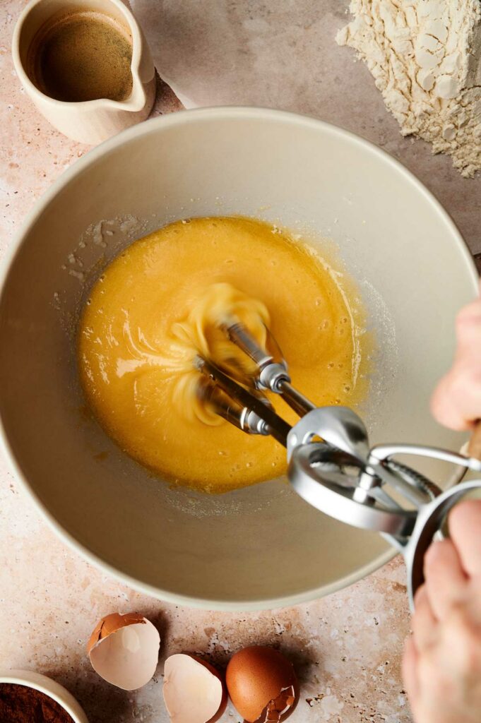 A person whisking eggs in a bowl.