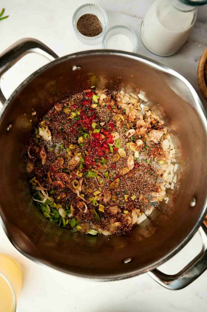 A pan full of Jamaican red beans and rice, sprinkled with spices, on a table.