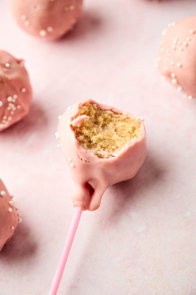 Starbucks-inspired pink cake pops with a bite taken out of them.