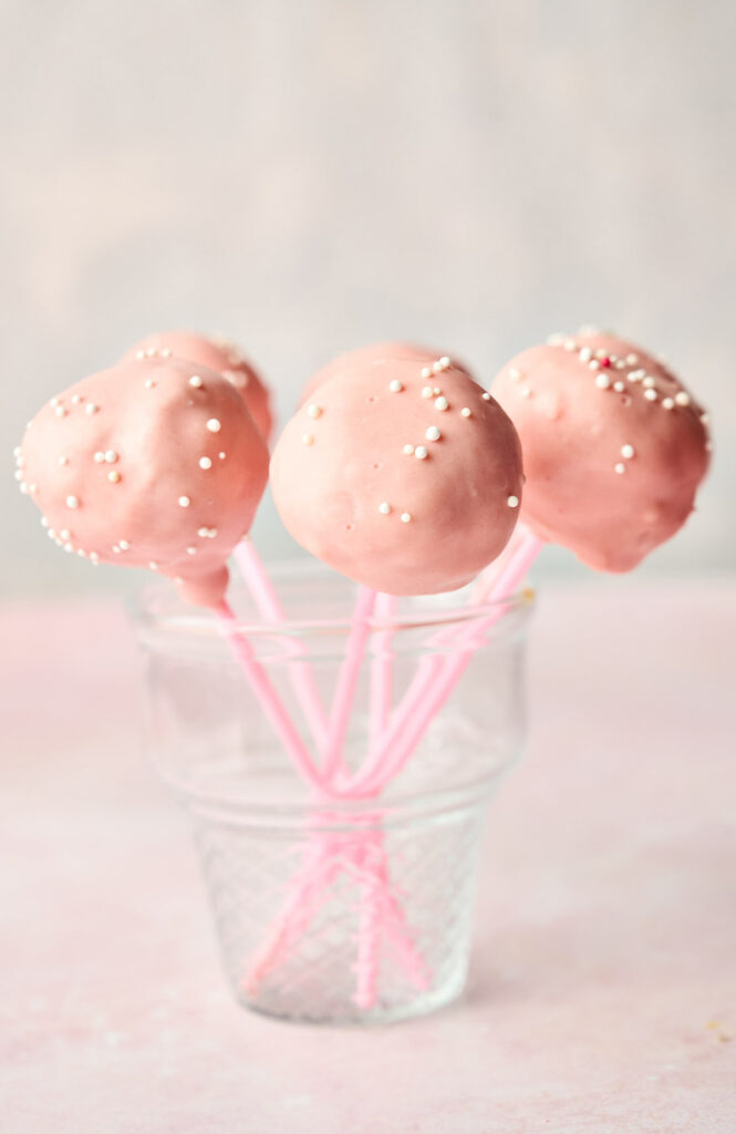 Starbucks pink frosted cake pops in a glass.