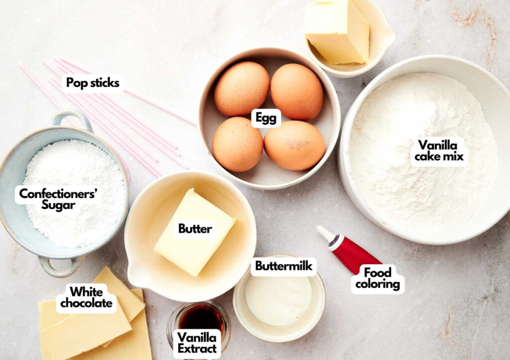 Baking ingredients and utensils arranged on a countertop, ready to create delicious treats inspired by the Starbucks cake pops recipe, including eggs, vanilla cake mix, butter, buttermilk, white chocolate, confectioners&rsquo; sugar, vanilla extract, food coloring, and pop sticks.