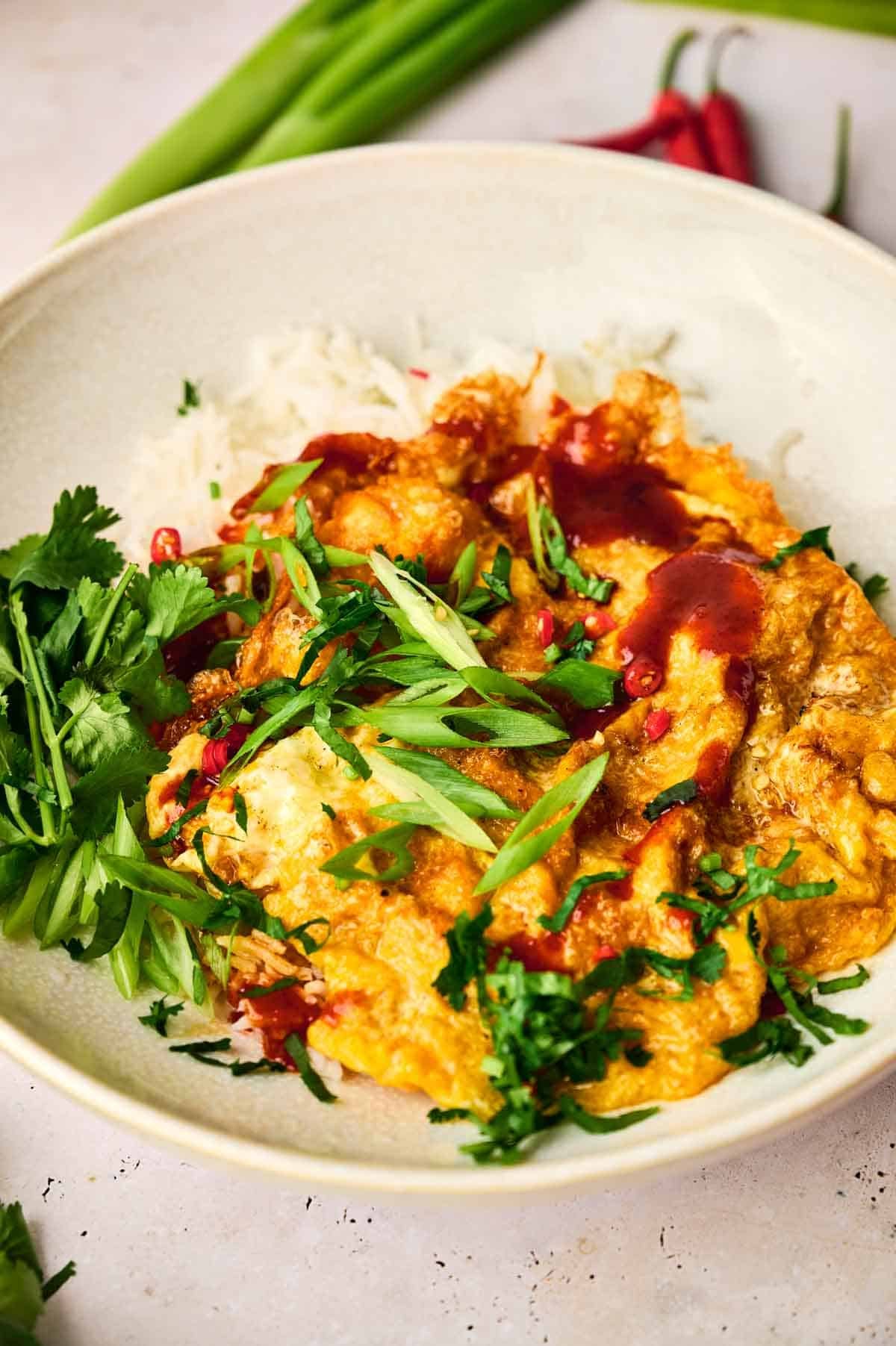 A plate of food with Thai omelette and greens on it.