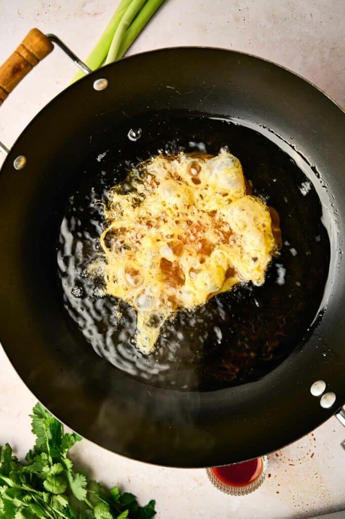 A Thai omelette cooking in a pan.