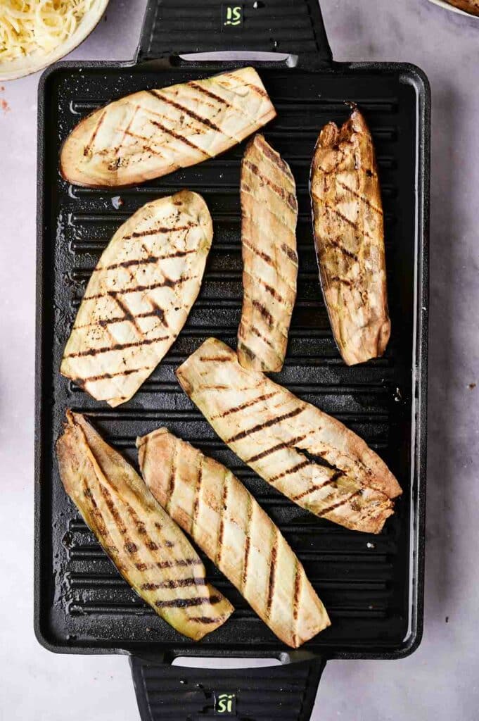 Grilled eggplant slices on a griddle pan for an eggplant casserole.