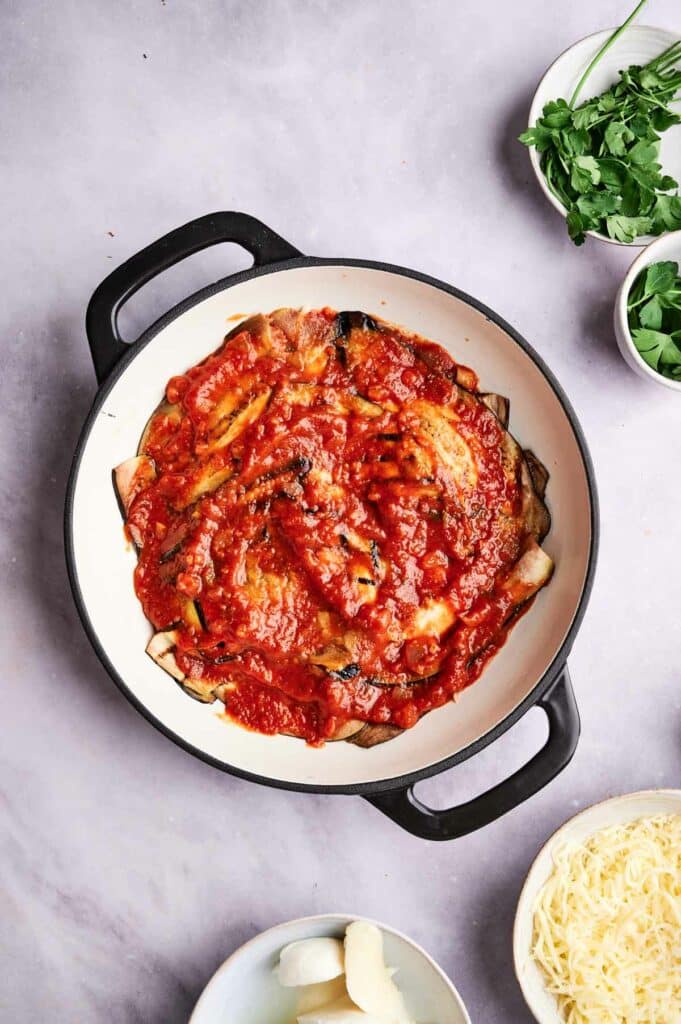 A pan of eggplant casserole with sauce.