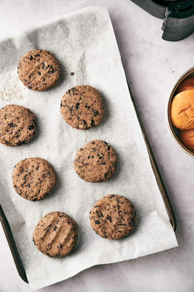 A batch of black bean sliders patties on a baking dish.