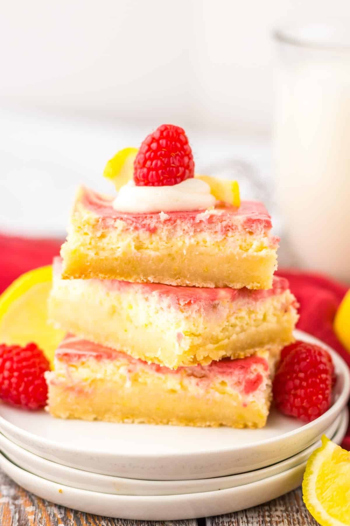 A pile of Raspberry Lemon Cheesecake Bars on a plate.